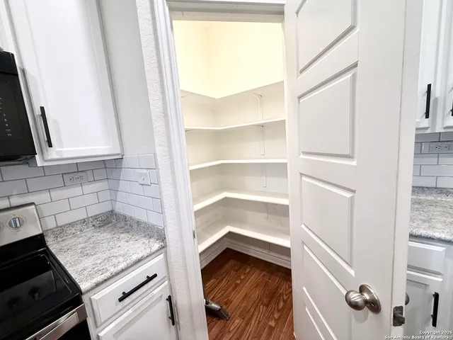 a kitchen with a refrigerator a microwave a sink and wooden floor