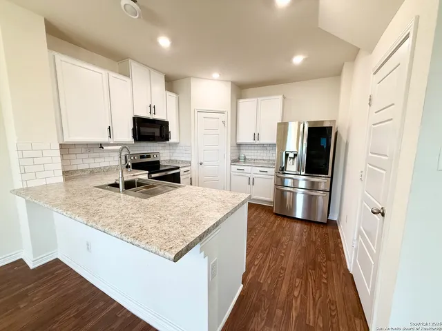 a large kitchen with kitchen island a sink stainless steel appliances and cabinets