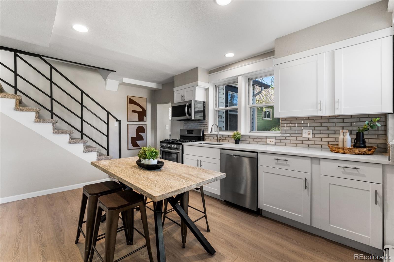 2259 Depew Street Edgewater, CO 80214 - Photo 5 of 46 a kitchen with stainless steel appliances granite countertop a stove and white cabinets