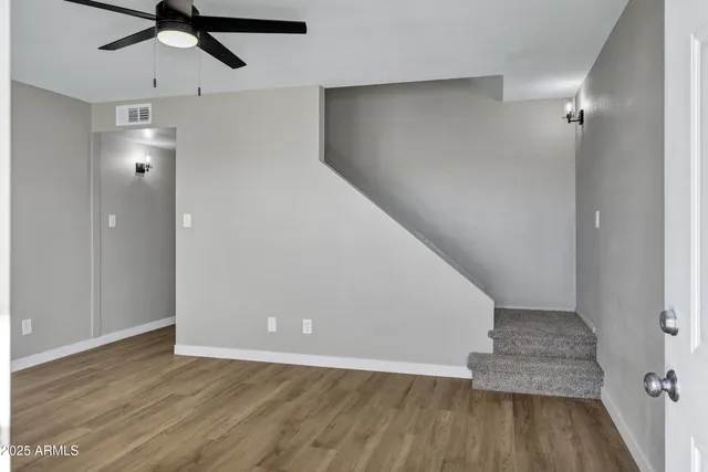 an empty room with wooden floor cabinet and entryway