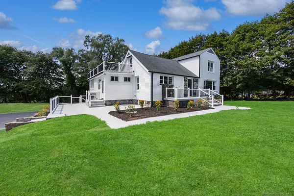 a view of a house with backyard and sitting area