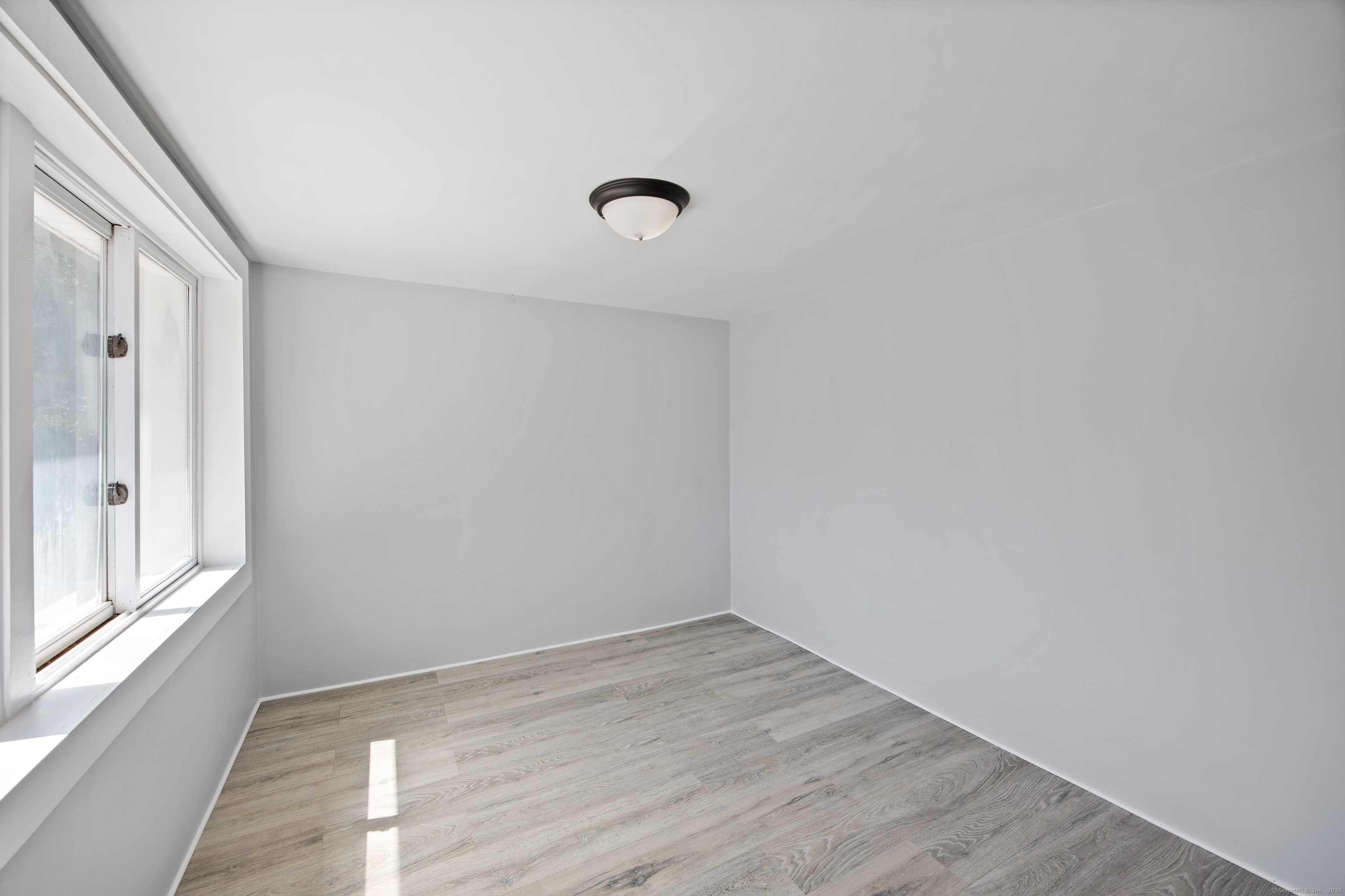 719 High Street Extension Thomaston, CT 06787 - Photo 15 of 38 an empty room with wooden floor and windows