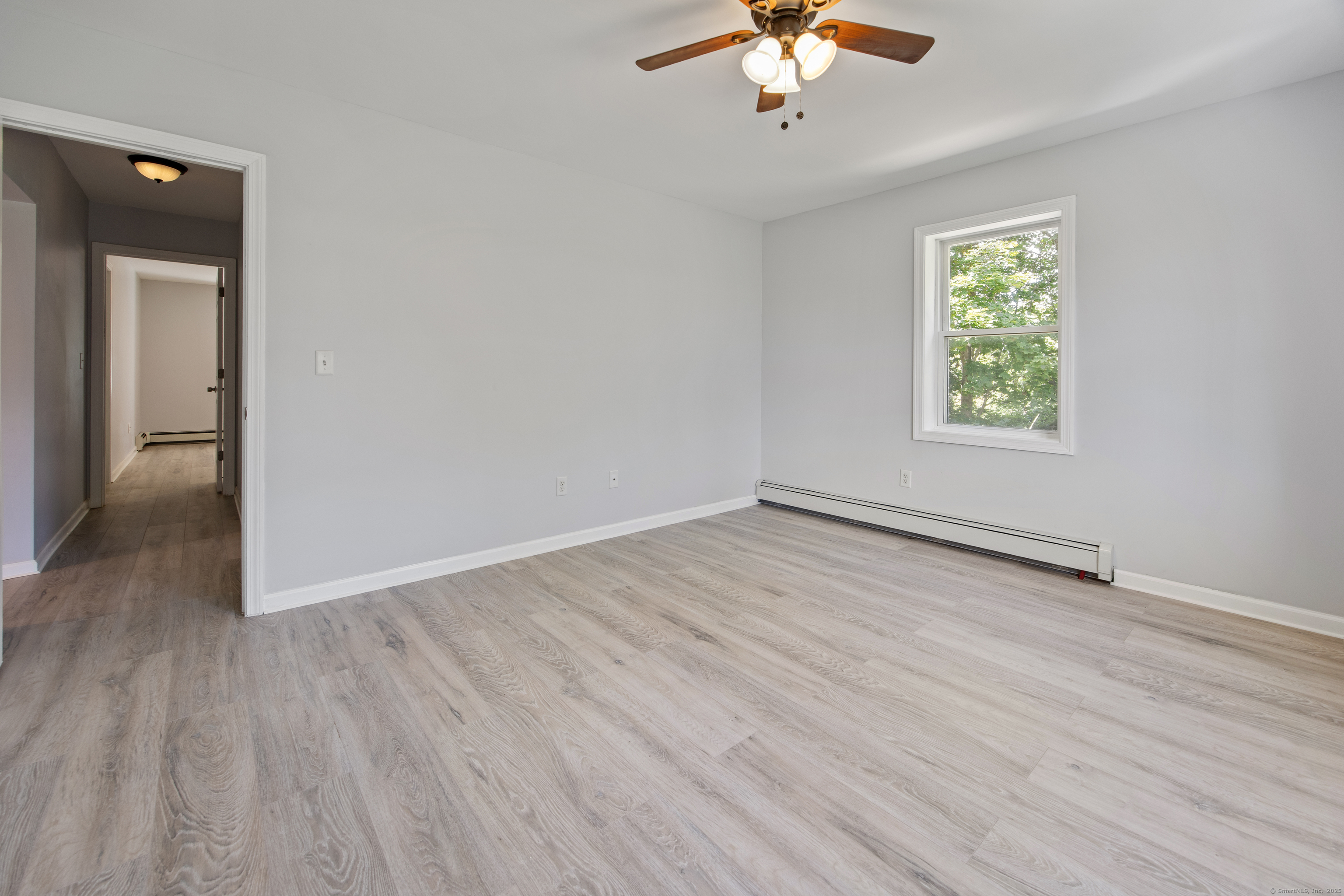 719 High Street Extension Thomaston, CT 06787 - Photo 30 of 38 an empty room with wooden floor chandelier fan and windows