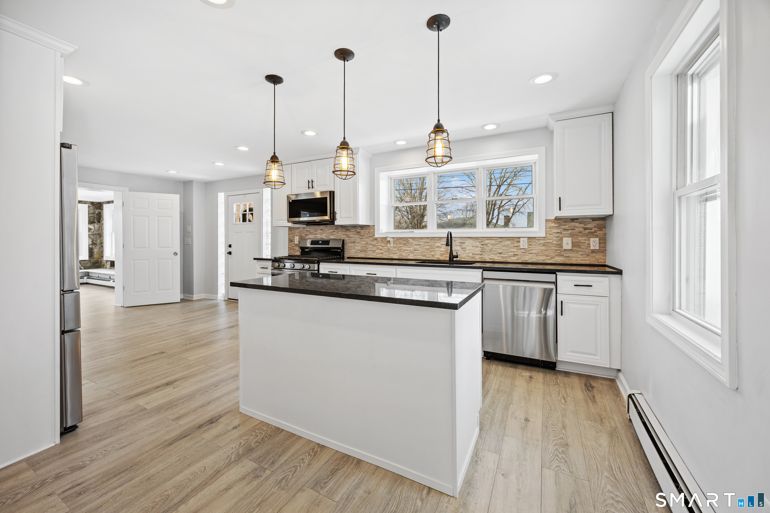 719 High Street Extension Thomaston, CT 06787 - Photo 5 of 38 a kitchen with stainless steel appliances granite countertop a sink a stove a refrigerator and white cabinets with wooden floor