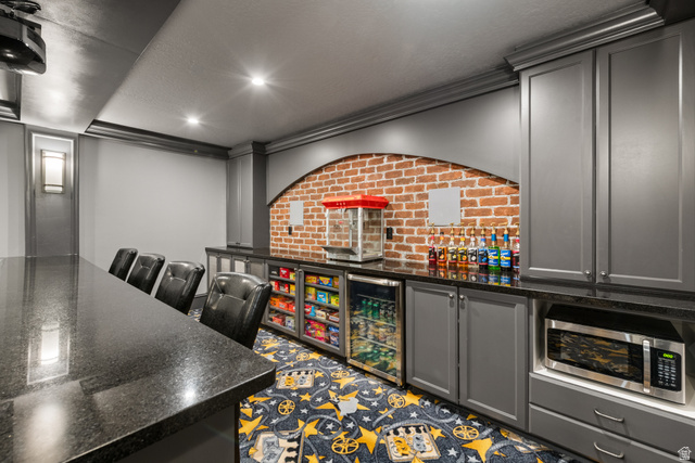 1205 North Elk Rdg Lane, Unit 202 Alpine, UT 84004 - Photo 55 of 88 Entertainment area featuring a long black countertop, recessed lighting, and a brick-finish accent wall