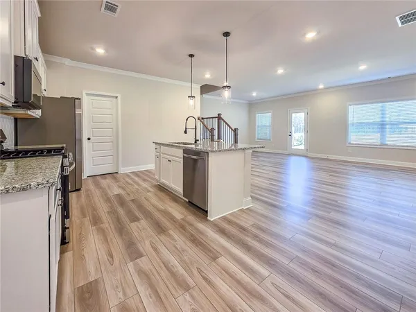 a kitchen with stainless steel appliances granite countertop a sink stove and wooden floor