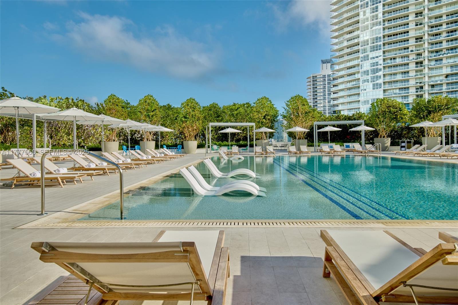 500 Alton Road, Unit 801 Miami Beach, FL 33139 - Photo 20 of 36 a view of a swimming pool with a lawn chairs and lake view