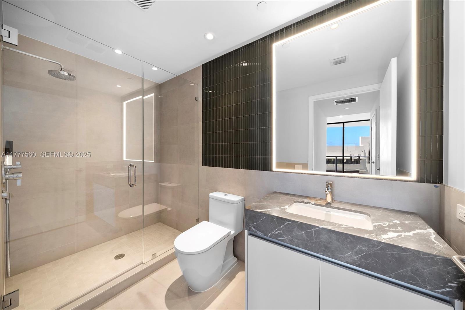 500 Alton Road, Unit 801 Miami Beach, FL 33139 - Photo 33 of 36 a bathroom with a granite countertop sink a toilet a mirror and shower