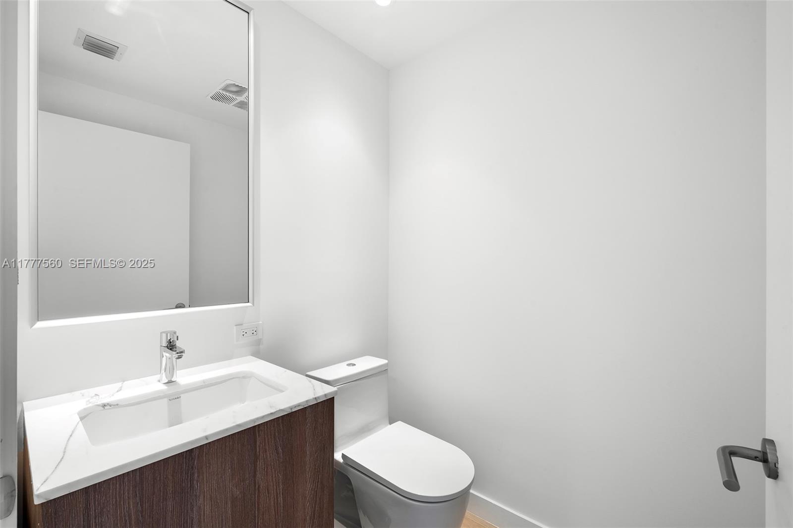 500 Alton Road, Unit 801 Miami Beach, FL 33139 - Photo 35 of 36 a bathroom with a sink a toilet and mirror