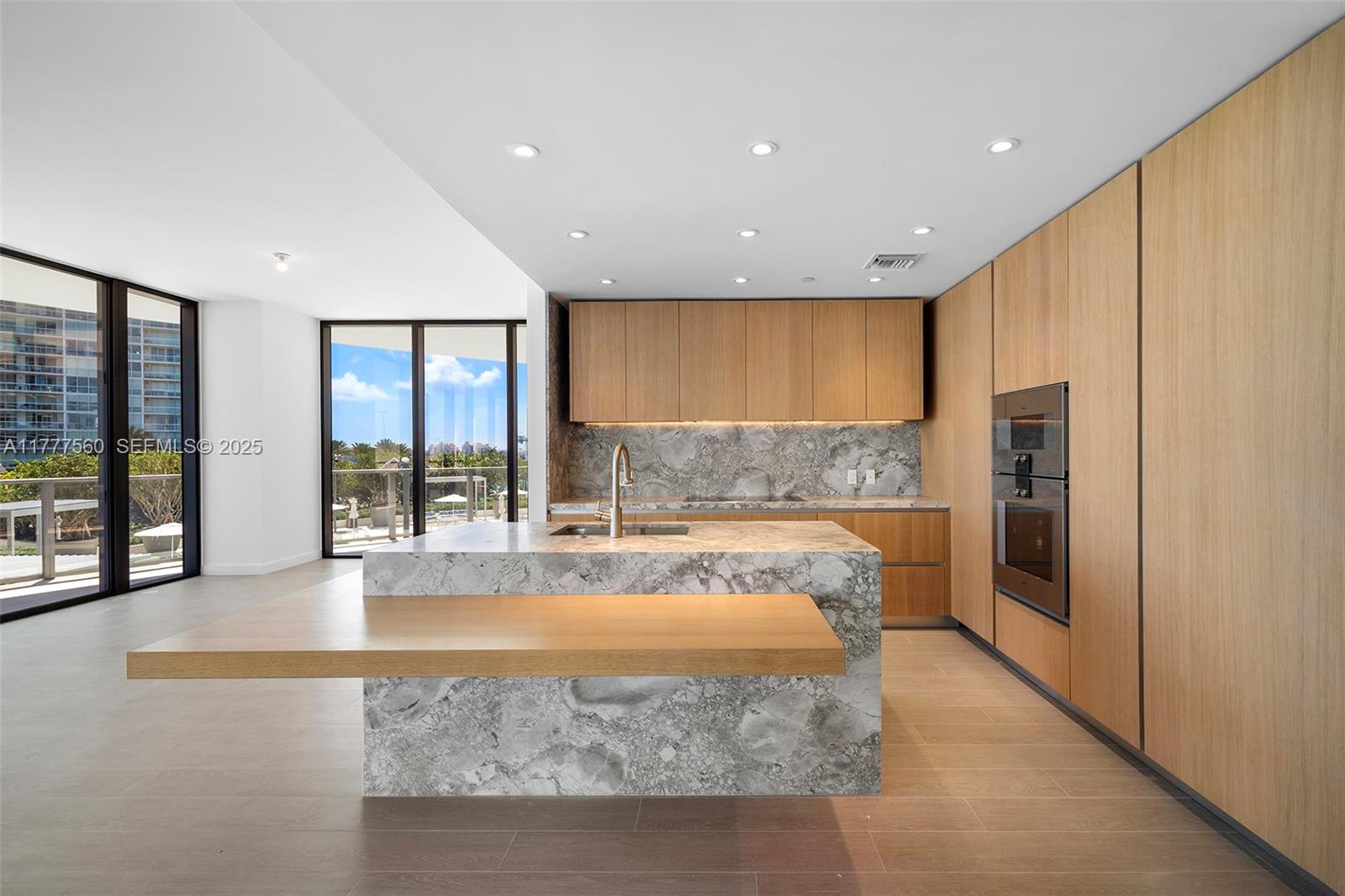 500 Alton Road, Unit 801 Miami Beach, FL 33139 - Photo 9 of 36 a large kitchen with granite countertop a large window and a refrigerator