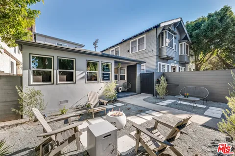 a view of a dinning table and chairs in backyard of the house