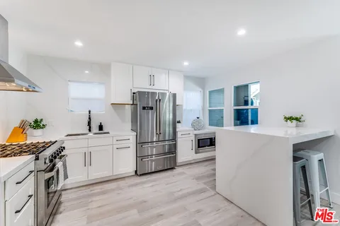 a kitchen with white cabinets and stainless steel appliances