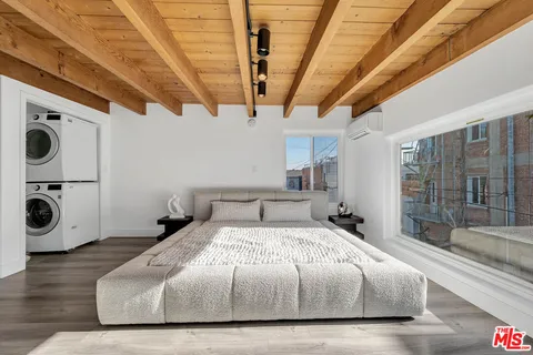 a spacious bedroom with a bed and a large window