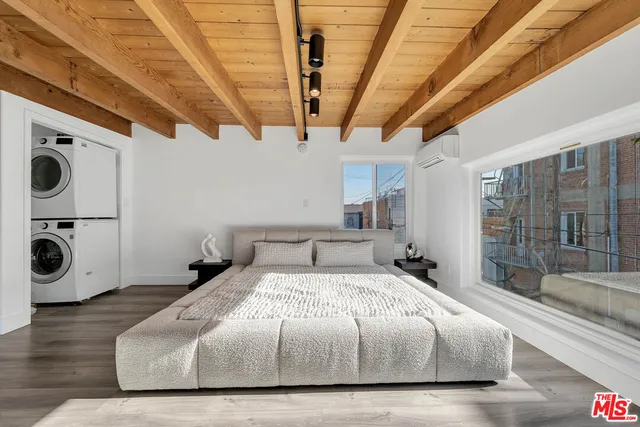 a spacious bedroom with a bed and a large window