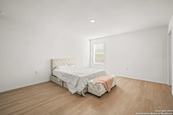 a bedroom with a bed and wooden floor