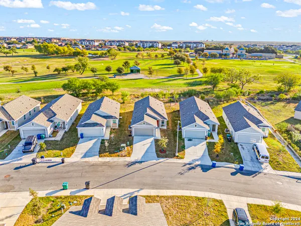 an aerial view of residential houses with outdoor space and ocean view