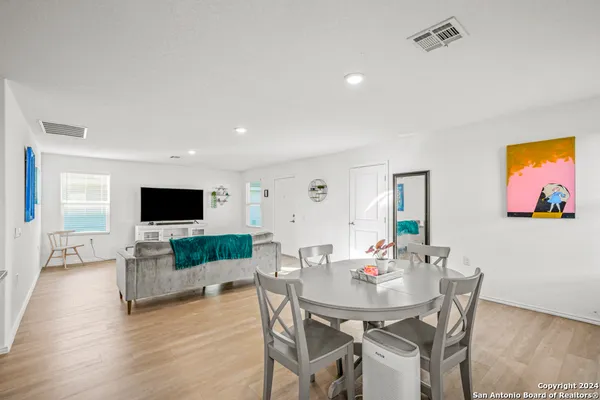 a living room with furniture a flat screen tv and kitchen view