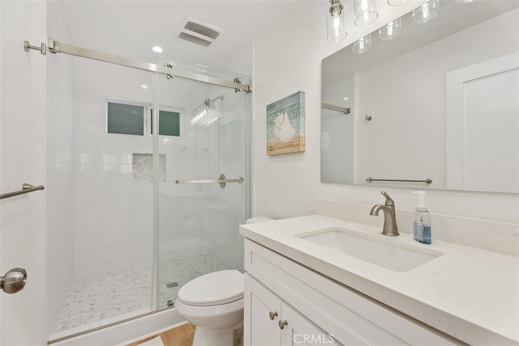 808 West Oceanfront Newport Beach, CA 92661 - Photo 14 of 34 a bathroom with a sink toilet a mirror and shower