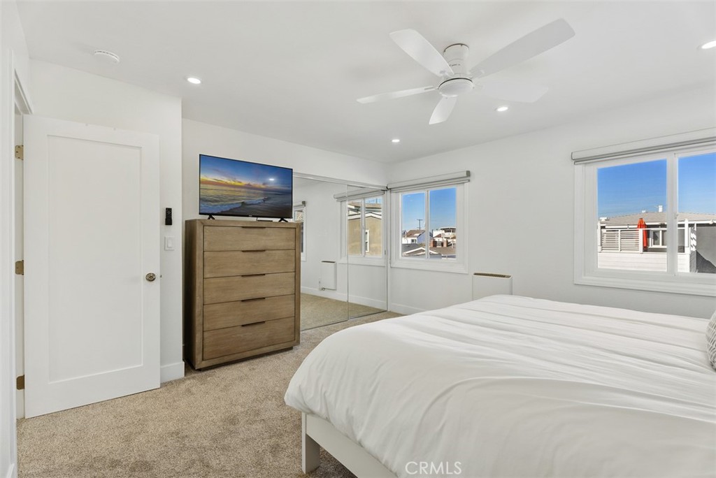 808 West Oceanfront Newport Beach, CA 92661 - Photo 19 of 34 a spacious bedroom with a bed and a ceiling fan