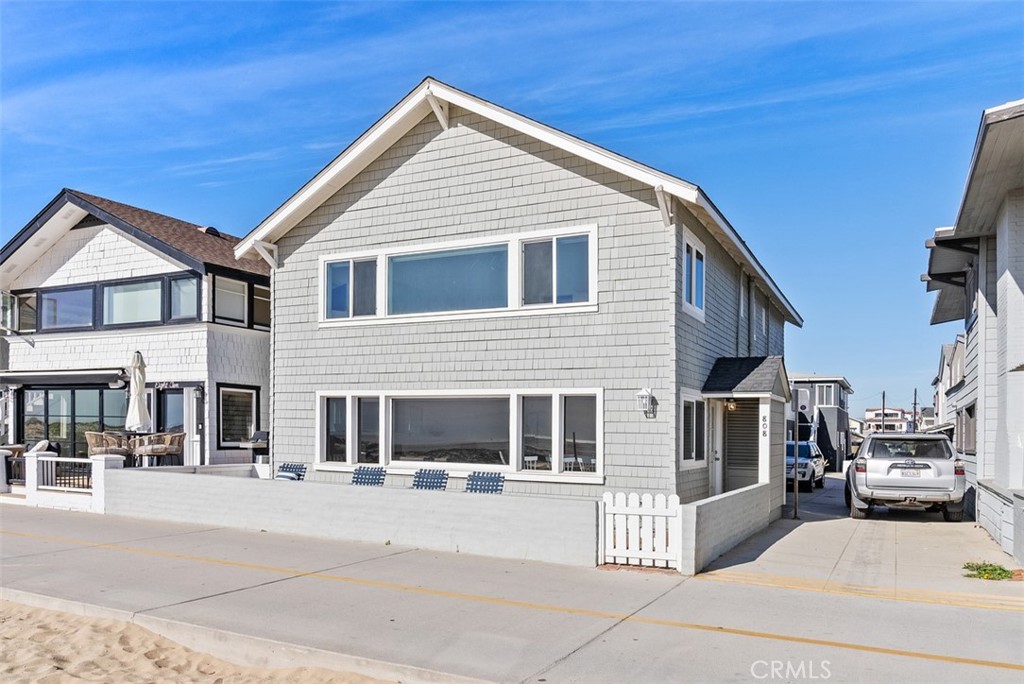 808 West Oceanfront Newport Beach, CA 92661 - Photo 30 of 34 a view of a white house with large windows and a small yard