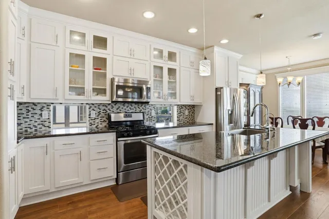 a kitchen with stainless steel appliances granite countertop a stove and a sink