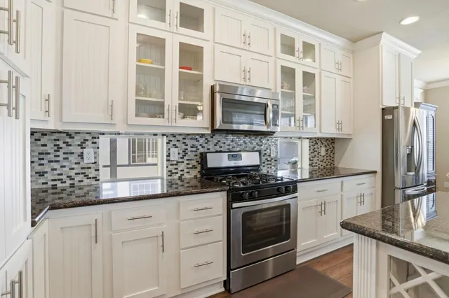a kitchen with stainless steel appliances granite countertop a stove and a refrigerator