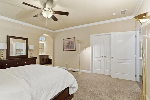 a bedroom with a large bed and a chandelier
