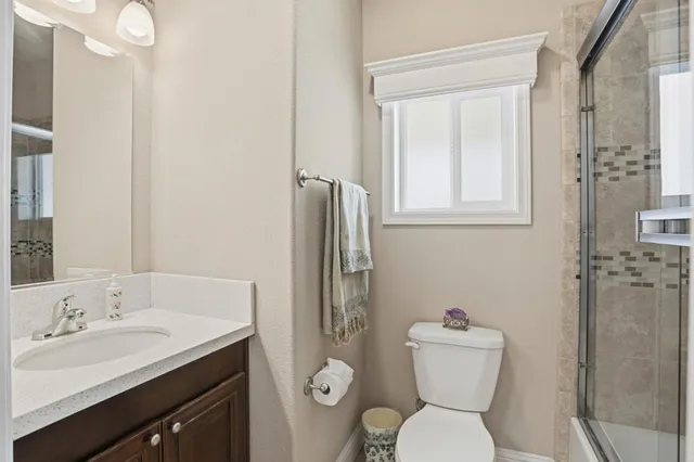 a bathroom with a toilet sink shower and mirror