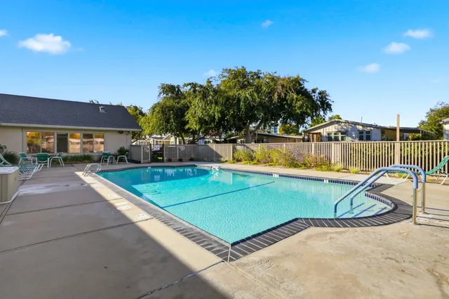 a view of a swimming pool with a patio and a yard