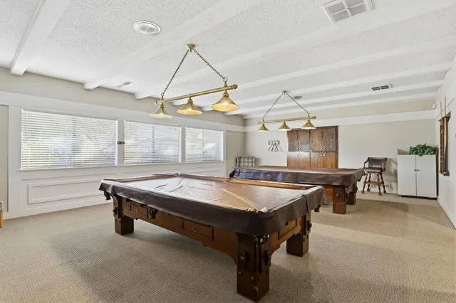 a room with pool table and windows