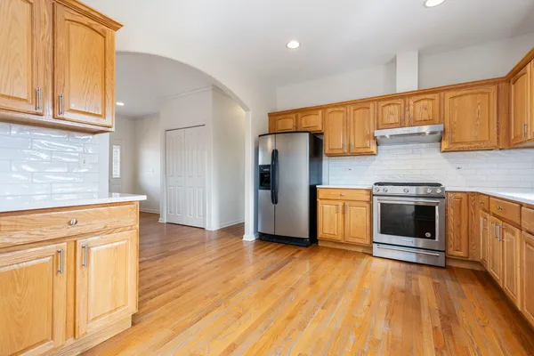 a kitchen with granite countertop wooden floors and stainless steel appliances