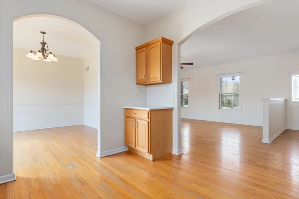 an empty room with wooden floor and cabinet