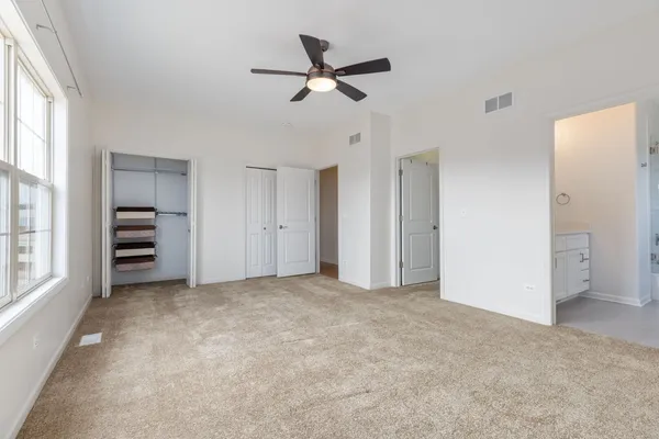 an empty room with closet and windows
