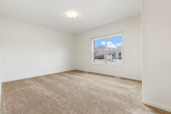 an empty room with windows and cabinet