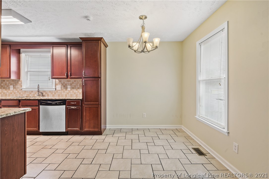 6568 Applewhite Road Fayetteville, NC 28304 - Photo 13 of 46 a kitchen with granite countertop a stove a sink and a refrigerator