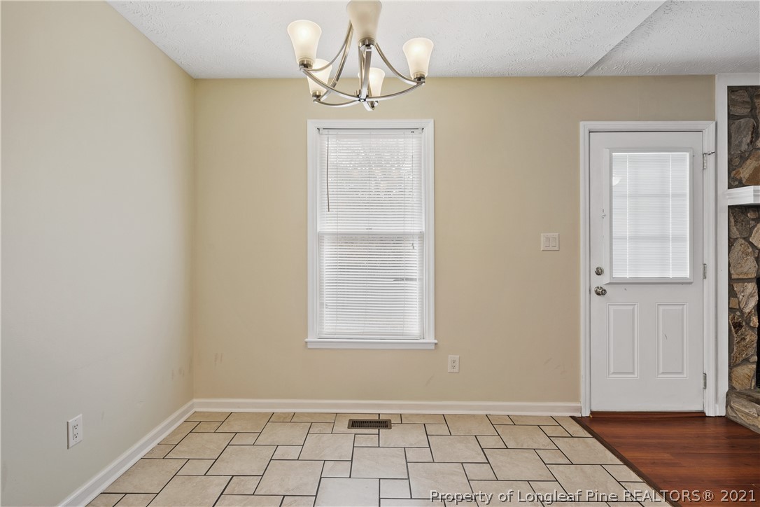 6568 Applewhite Road Fayetteville, NC 28304 - Photo 14 of 46 a view of an empty room with window and wooden floor