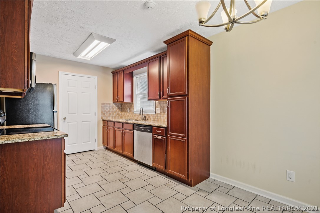 6568 Applewhite Road Fayetteville, NC 28304 - Photo 15 of 46 a kitchen with stainless steel appliances granite countertop a refrigerator a sink and dishwasher