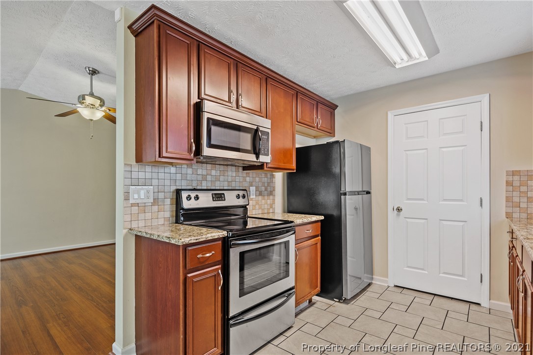 6568 Applewhite Road Fayetteville, NC 28304 - Photo 17 of 46 a kitchen with stainless steel appliances granite countertop a stove microwave and refrigerator
