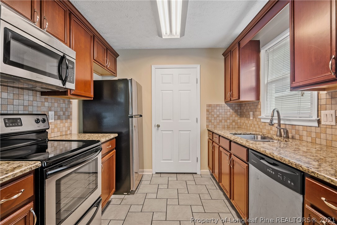 6568 Applewhite Road Fayetteville, NC 28304 - Photo 18 of 46 a kitchen with stainless steel appliances granite countertop a sink stove and refrigerator