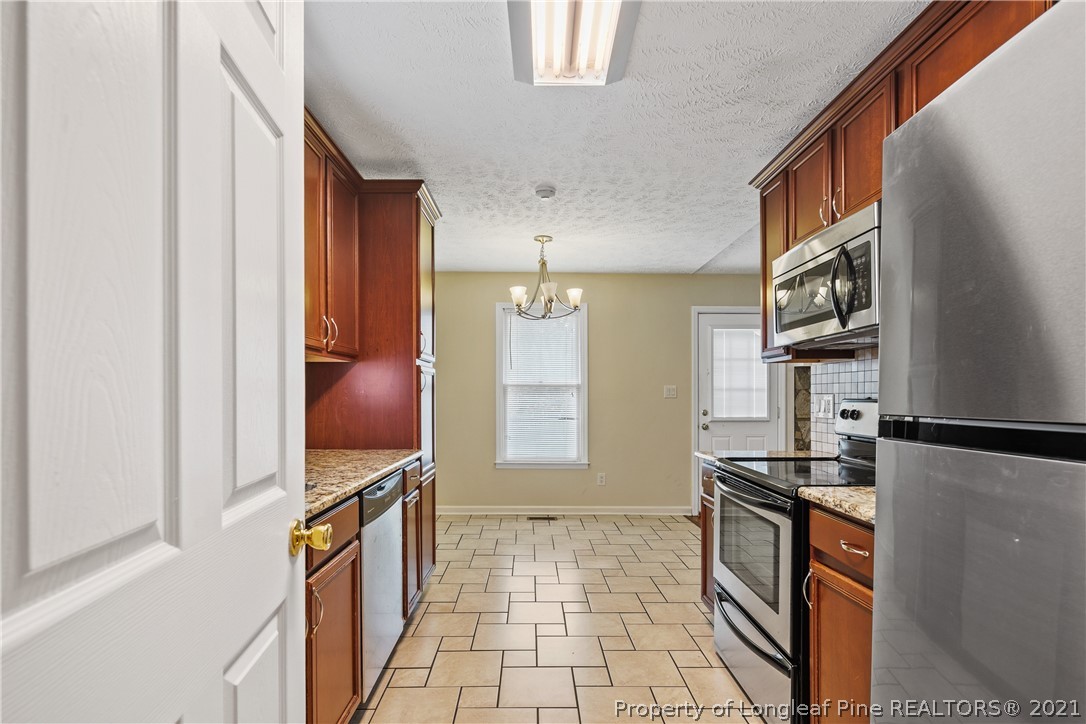 6568 Applewhite Road Fayetteville, NC 28304 - Photo 20 of 46 a kitchen with stainless steel appliances a refrigerator and a stove top oven