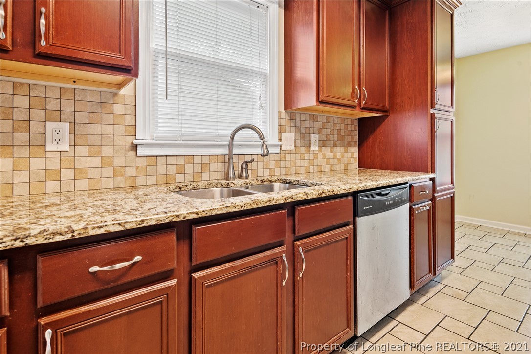 6568 Applewhite Road Fayetteville, NC 28304 - Photo 22 of 46 a kitchen with granite countertop cabinets sink and window