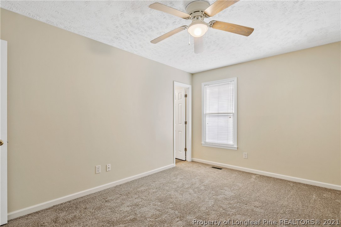 6568 Applewhite Road Fayetteville, NC 28304 - Photo 27 of 46 an empty room with a ceiling fan and a window