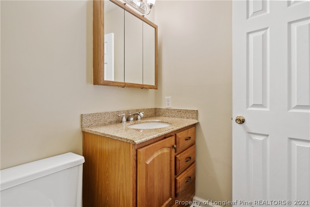 6568 Applewhite Road Fayetteville, NC 28304 - Photo 30 of 46 a bathroom with a sink a toilet and a mirror
