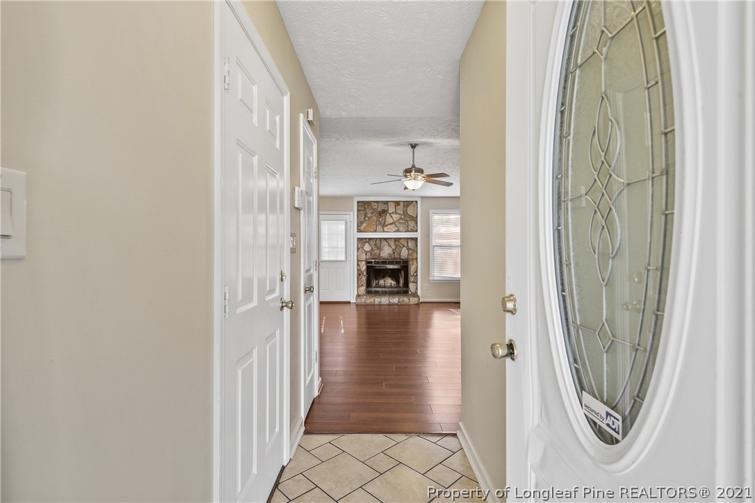 6568 Applewhite Road Fayetteville, NC 28304 - Photo 5 of 46 a view of a hallway with wooden floor and a bathroom