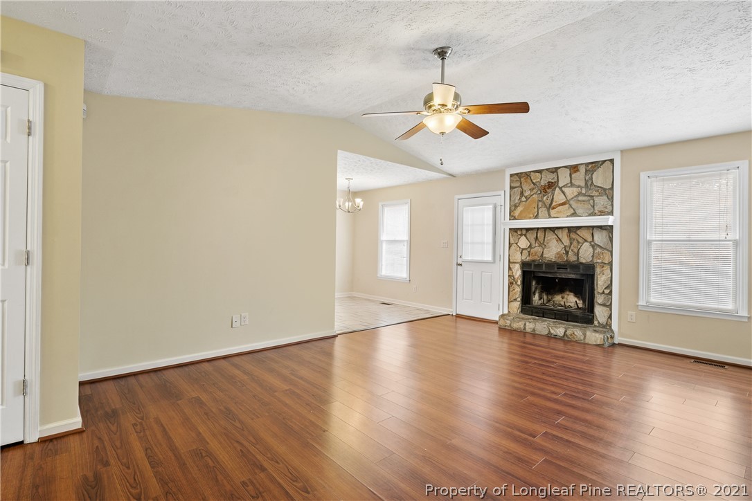 6568 Applewhite Road Fayetteville, NC 28304 - Photo 7 of 46 an empty room with wooden floor fireplace and window