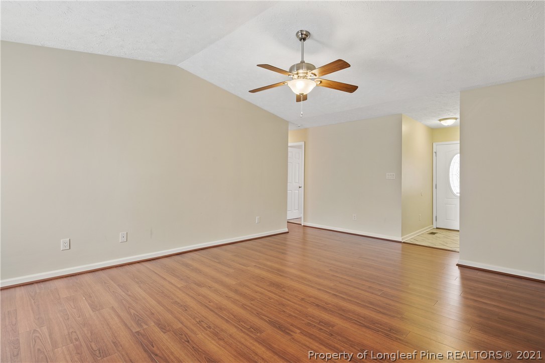 6568 Applewhite Road Fayetteville, NC 28304 - Photo 9 of 46 an empty room with wooden floor fan and windows