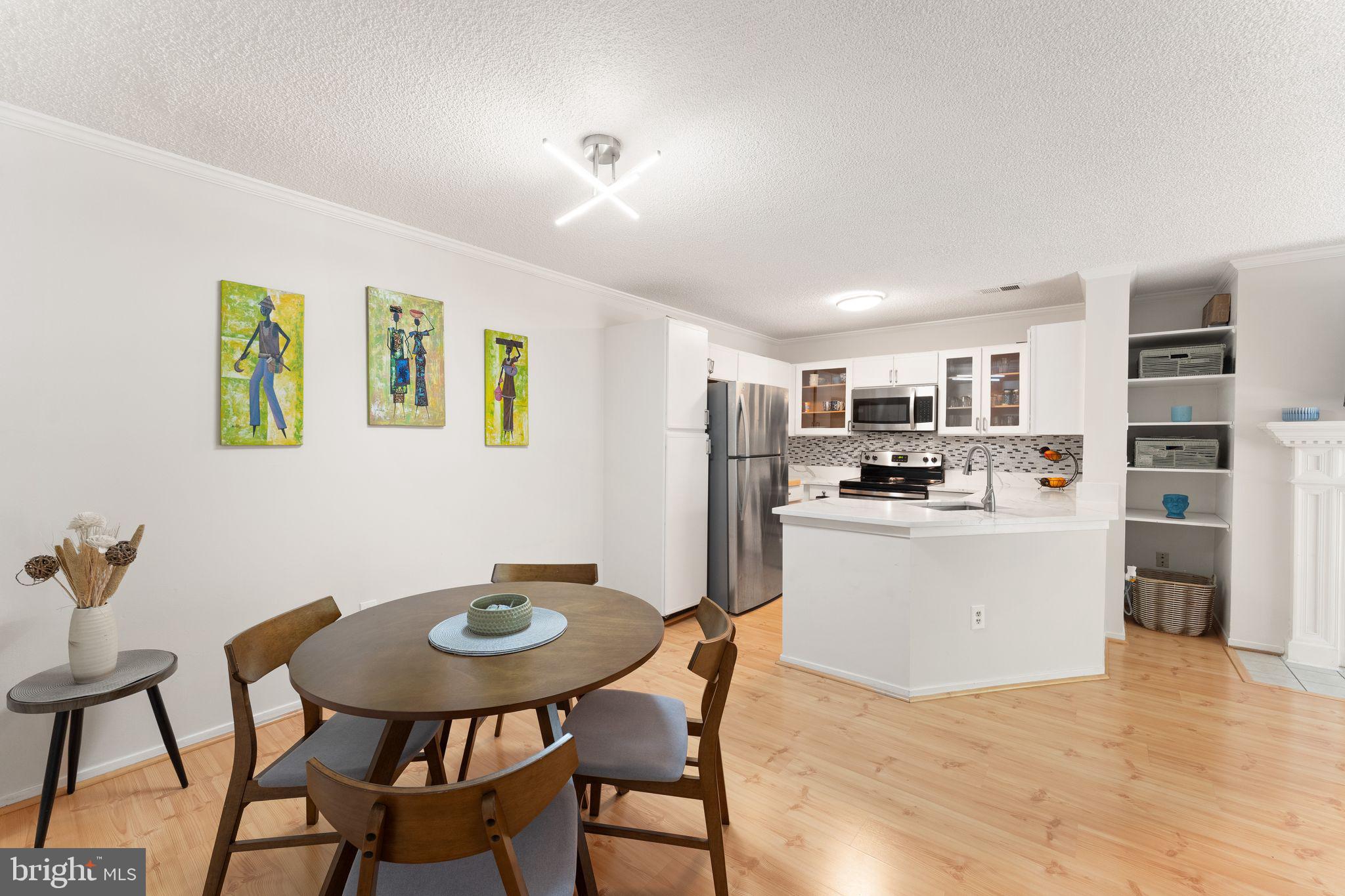 11741 Summerchase Circle, Unit A Reston, VA 20194 - Photo 14 of 32 a kitchen with stainless steel appliances kitchen island granite countertop a table chairs and a refrigerator