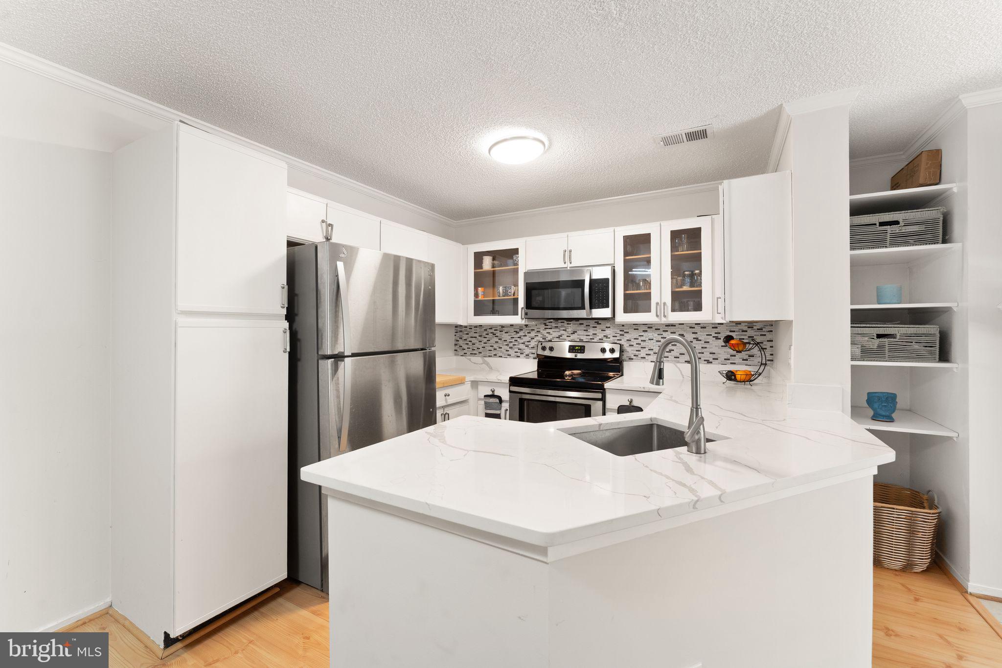 11741 Summerchase Circle, Unit A Reston, VA 20194 - Photo 16 of 32 a kitchen with stainless steel appliances a refrigerator sink and microwave