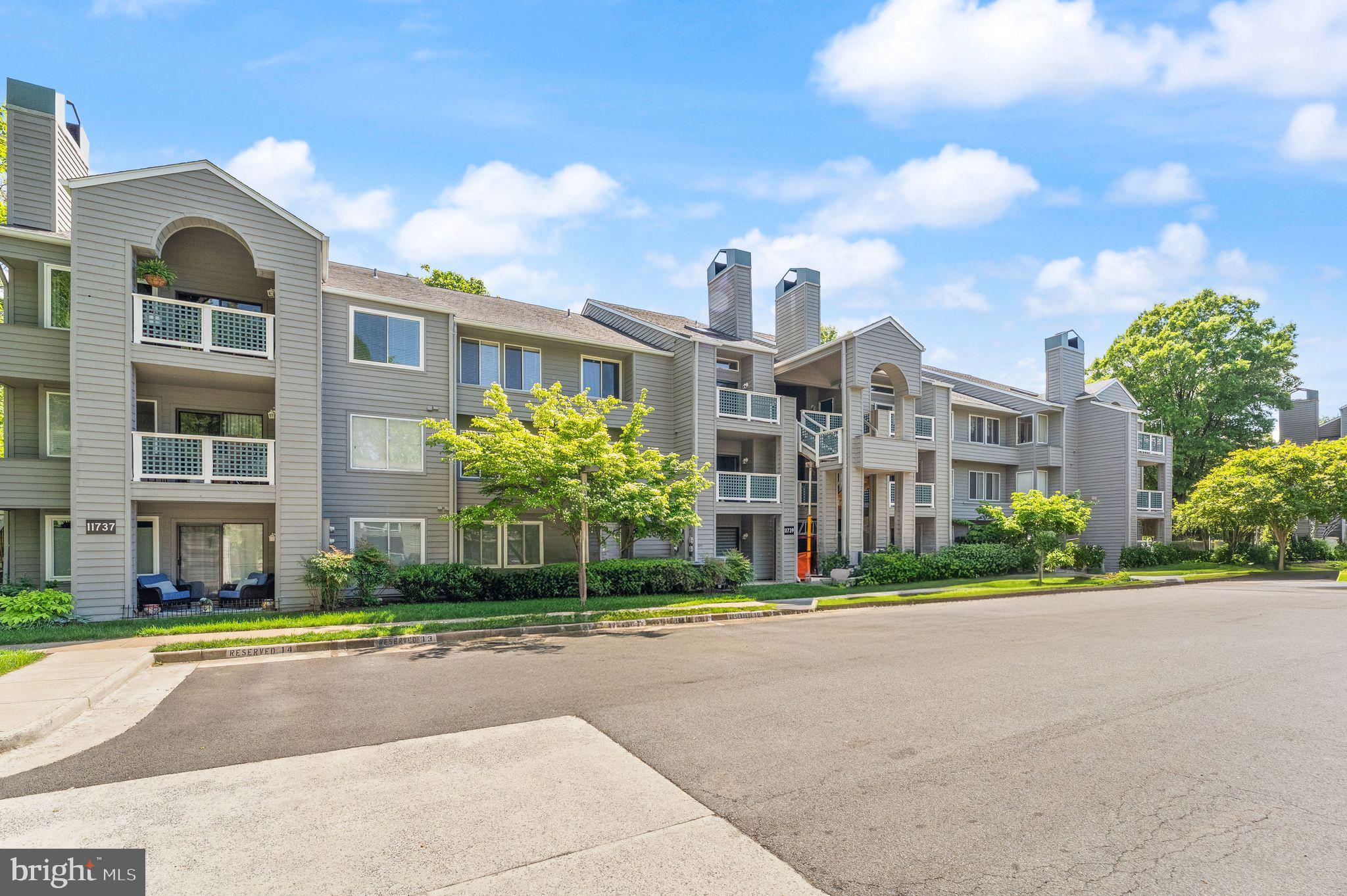 11741 Summerchase Circle, Unit A Reston, VA 20194 - Photo 31 of 32 a front view of a residential apartment building with a yard