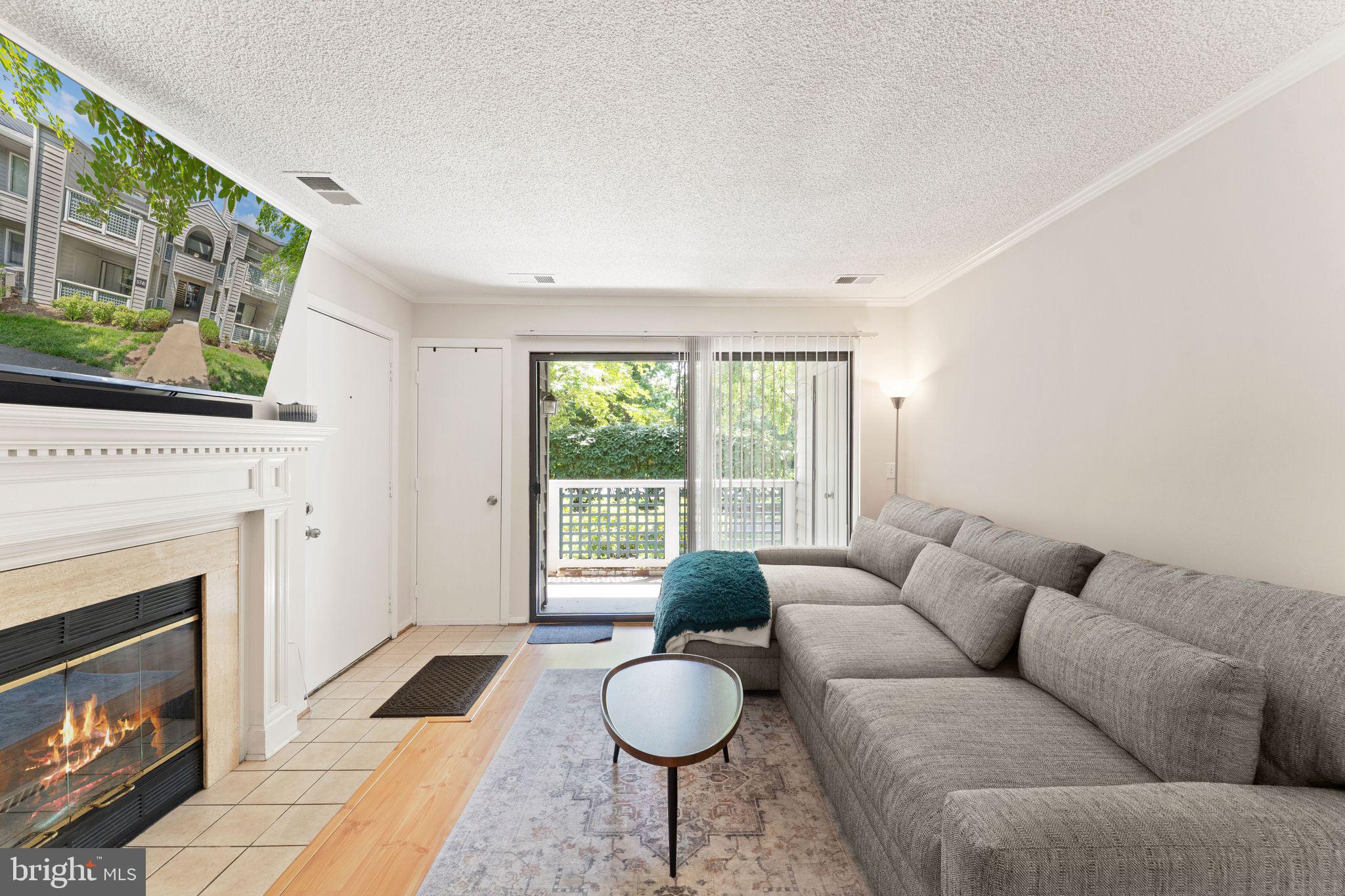 11741 Summerchase Circle, Unit A Reston, VA 20194 - Photo 9 of 32 a living room with furniture a flat screen tv and a fireplace